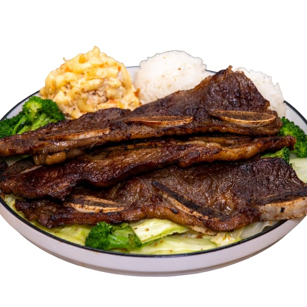Grilled short ribs with rice, macaroni salad, and broccoli on a white plate.