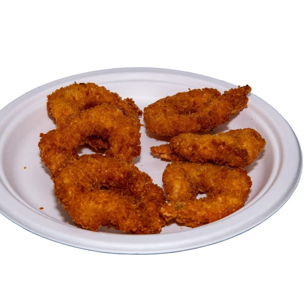 A white plate holds several pieces of golden-brown fried shrimp, breaded and crispy.