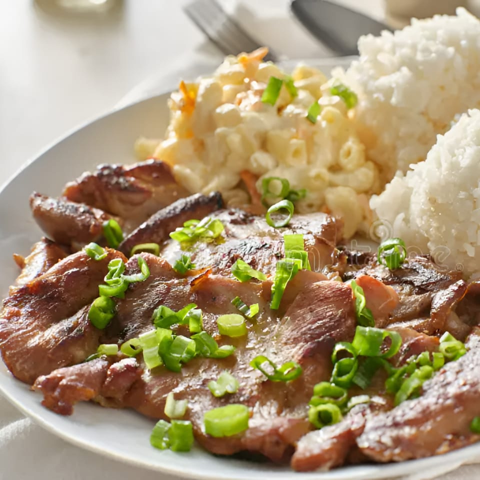 Hawaiian BBQ chicken with macaroni salad and white rice, garnished with green onions.